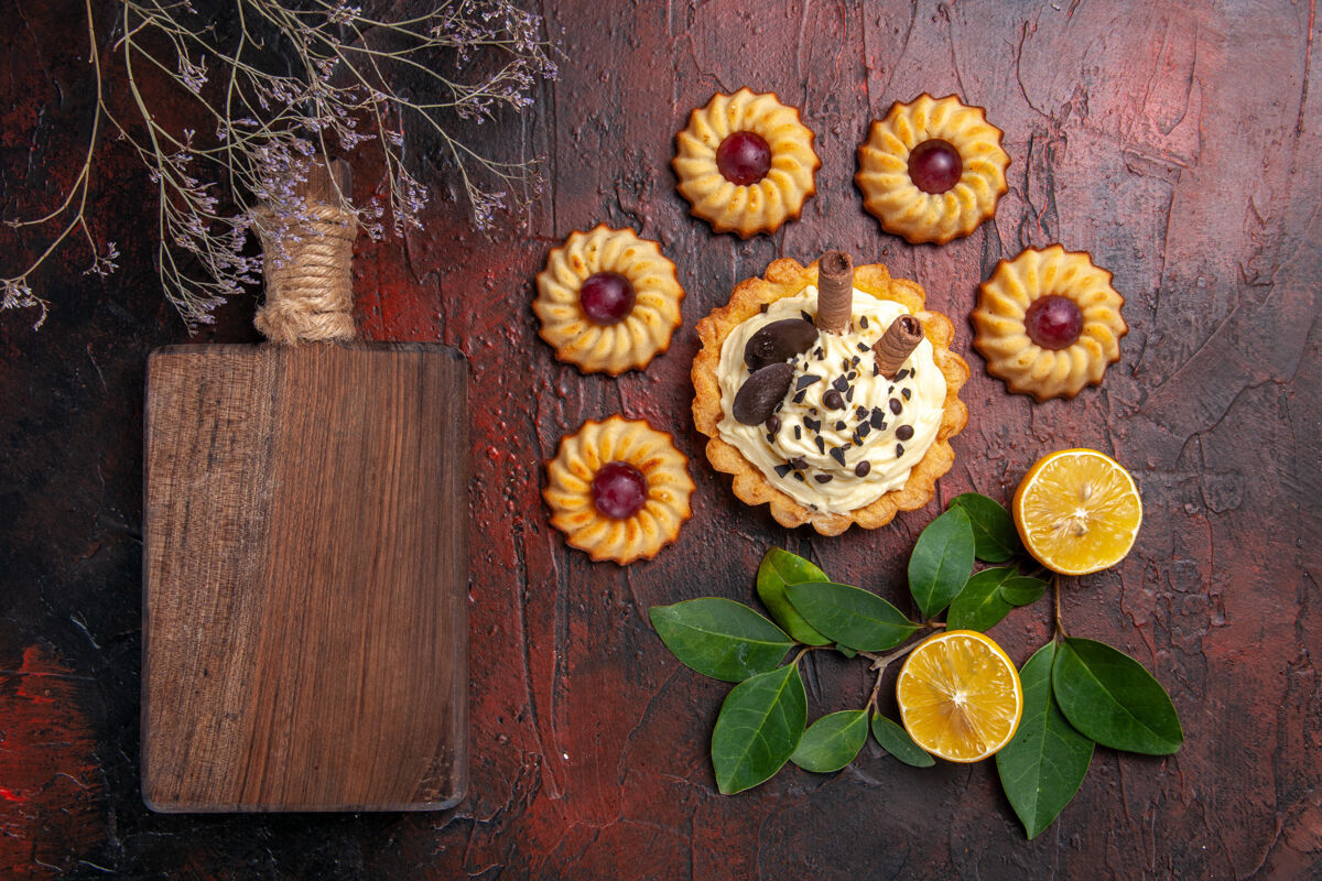 饼干顶视图美味的奶油蛋糕和饼干在黑暗的地板甜点甜饼干蛋糕饼干鲜花花朵