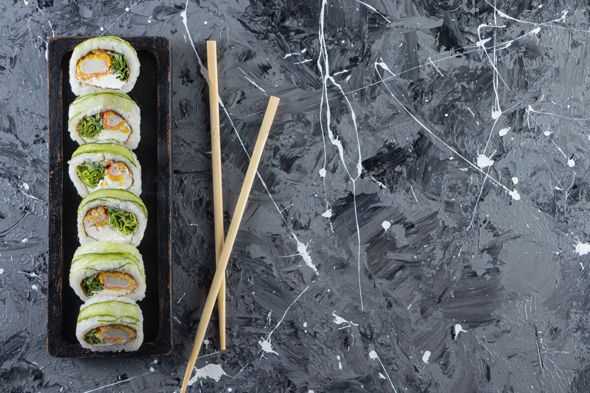 卷美味的寿司卷和金枪鱼放在石桌上晚餐平铺海鲜
