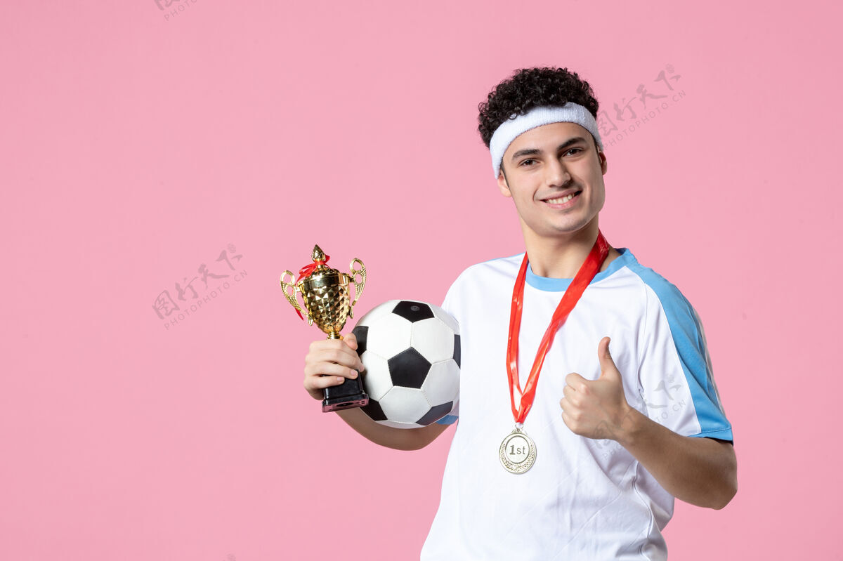 视图前视图穿着运动服的足球运动员拿着金杯和奖牌奖牌足球运动员金色