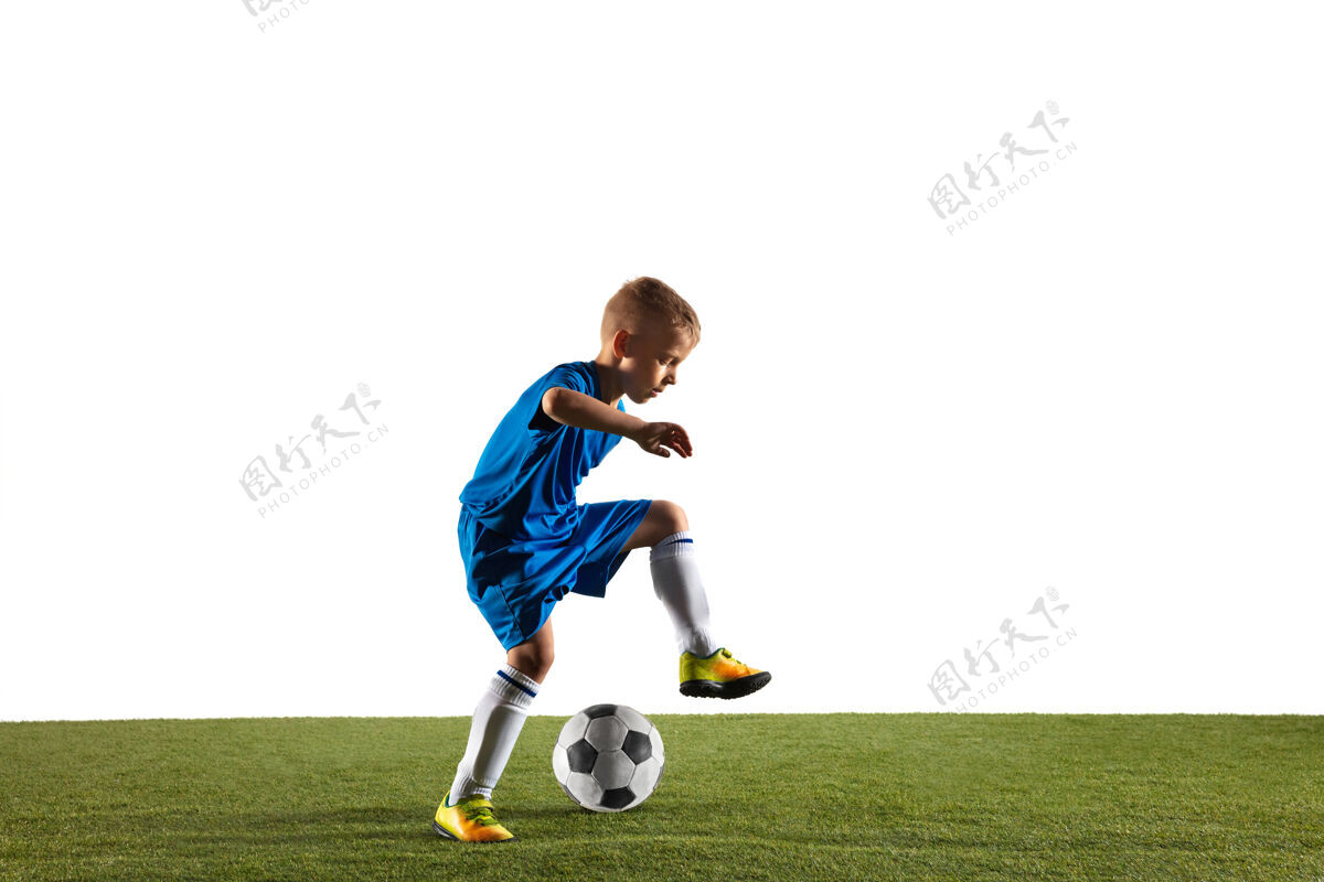 男孩穿运动服的足球运动员或足球运动员在白色背景下用球假装或踢进球的小男孩动态男比赛