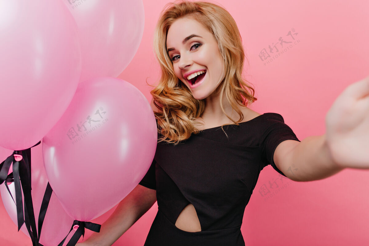 庆祝迷人的金发女孩 时尚的妆容 在派对上自拍带着气球欢笑的年轻女子 享受这一盛宴卷发年轻金发