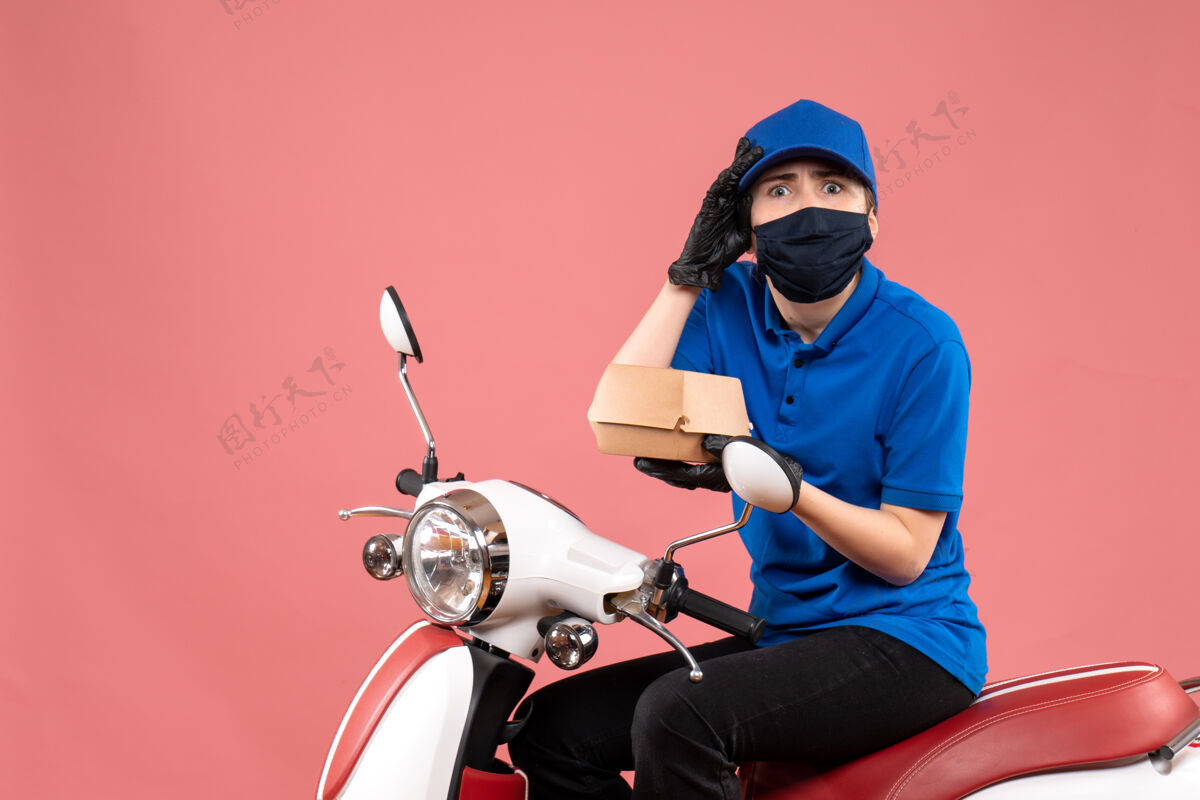 摩托车正面是戴着面具的女快递员 粉红色的小食品包装小工作服务