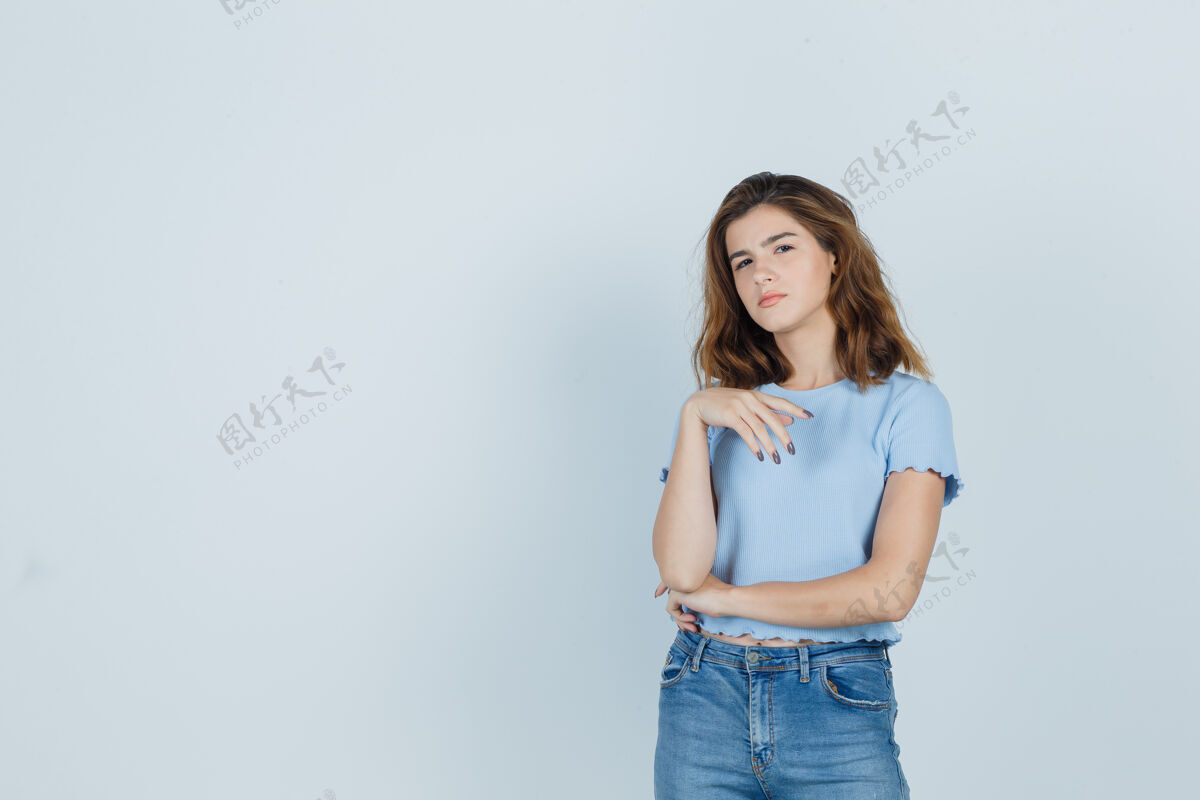 灵感穿着t恤和牛仔裤的年轻女孩站在思考的姿势 看起来很理智 正面视图年轻女人肖像
