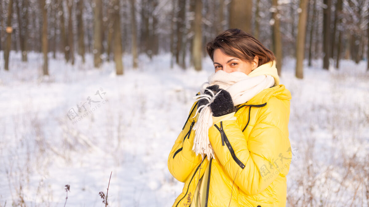公园美丽的年轻开朗的女人在雪景的冬日森林里玩得很开心 穿着暖和的衣服在冬天和雪里快乐微笑雪季节