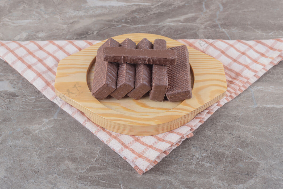 巧克力把涂有巧克力的薄饼放在大理石上的木盘上糖美味外套