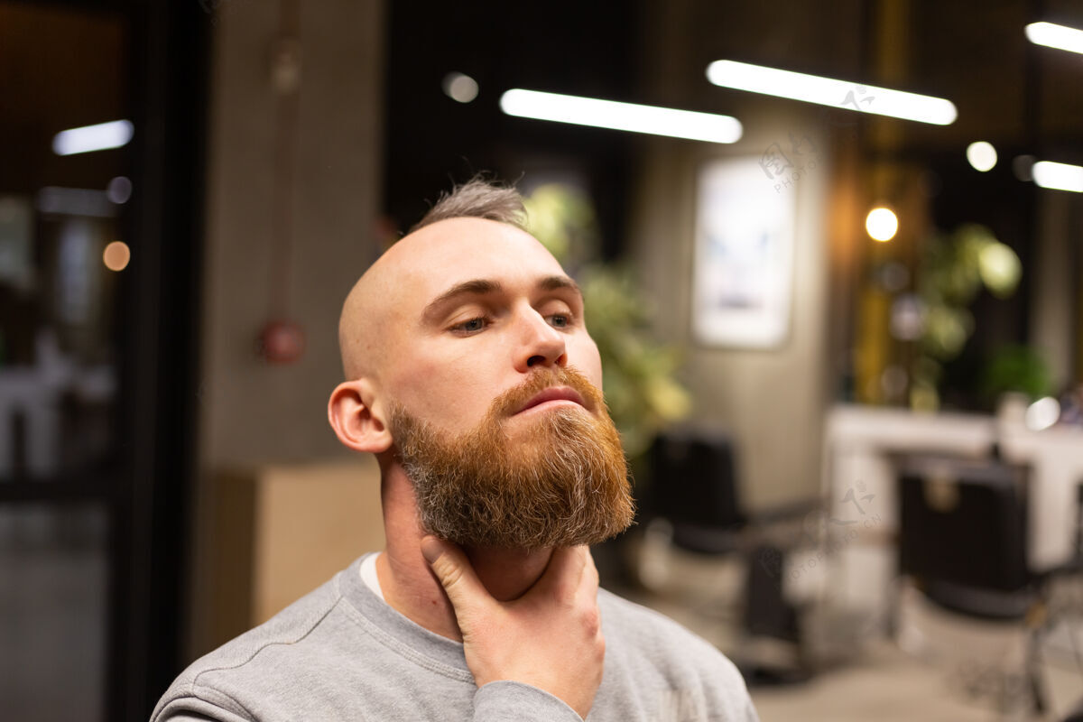 帅哥在理发店剪胡子的欧洲野蛮人年轻机器客户