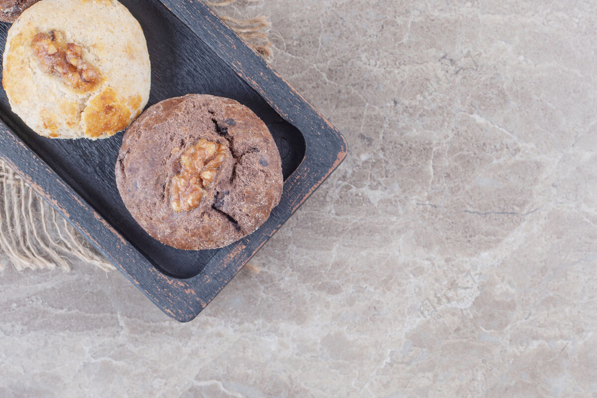 饼干在大理石上的黑色小托盘上放上核桃馅的饼干美味糕点美味