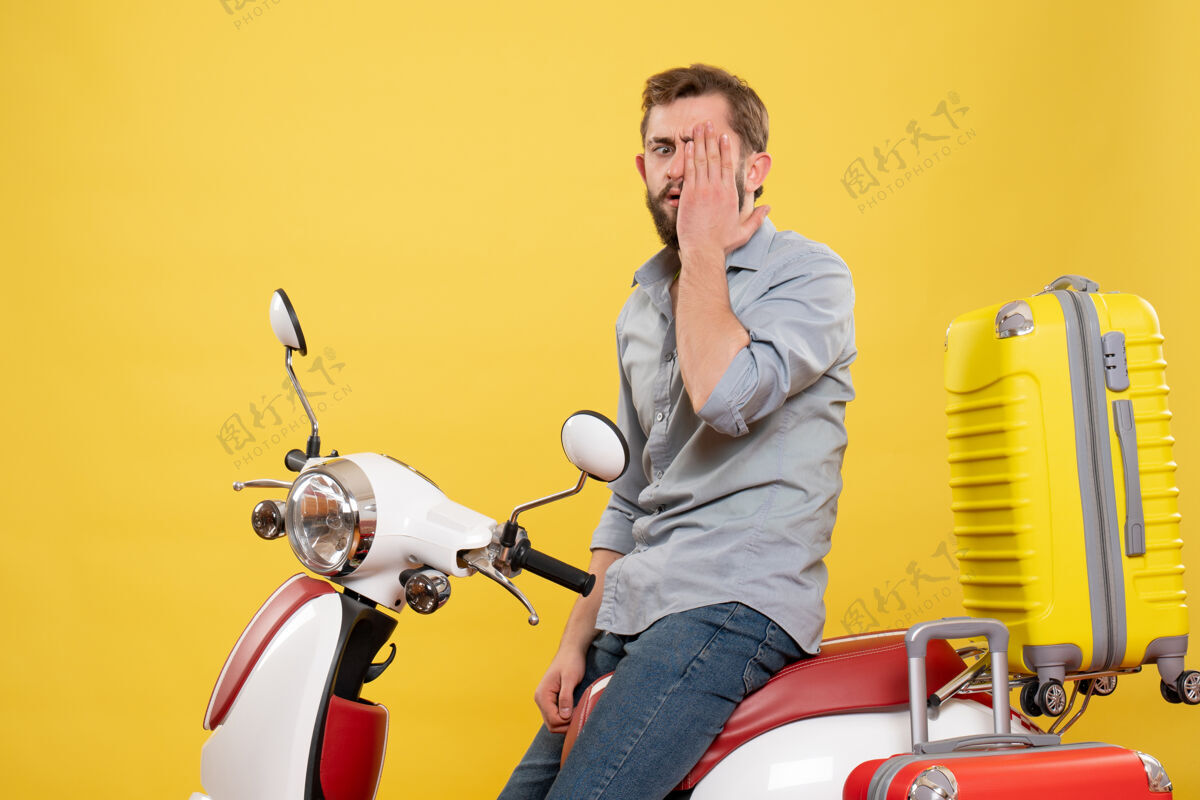 成人旅游概念与情绪紧张的年轻人坐在摩托车与手提箱上的黄色摩托车情感旅游