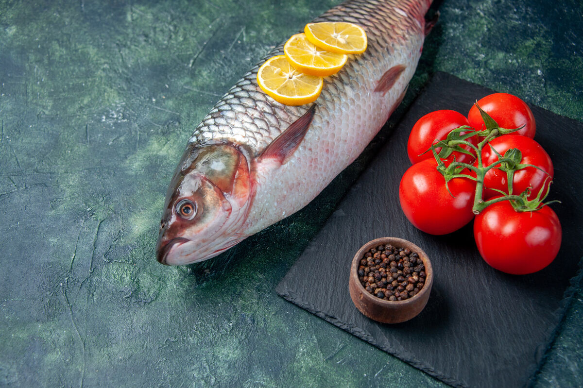 海鲜前视新鲜生鱼片和西红柿上的深蓝色表面鲨鱼海鲜餐海洋水平水肉类晚餐食品番茄景观肉
