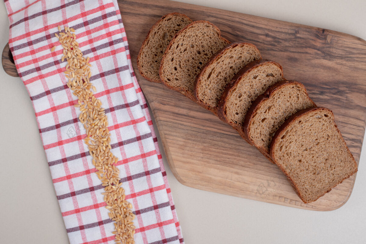 自然把新鲜的棕色面包片放在木板上新鲜营养面包皮