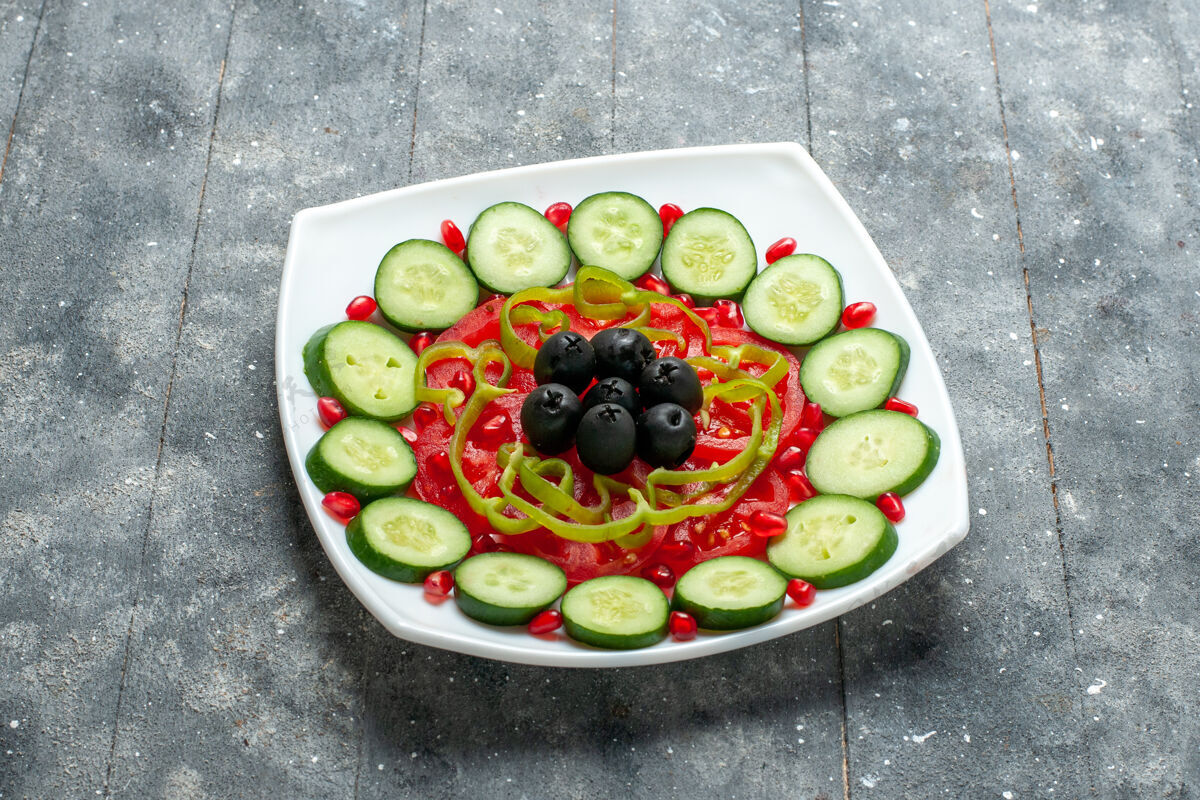可食用的水果在灰色的乡村书桌上 盘子里放着橄榄黄瓜片晚餐水果切片