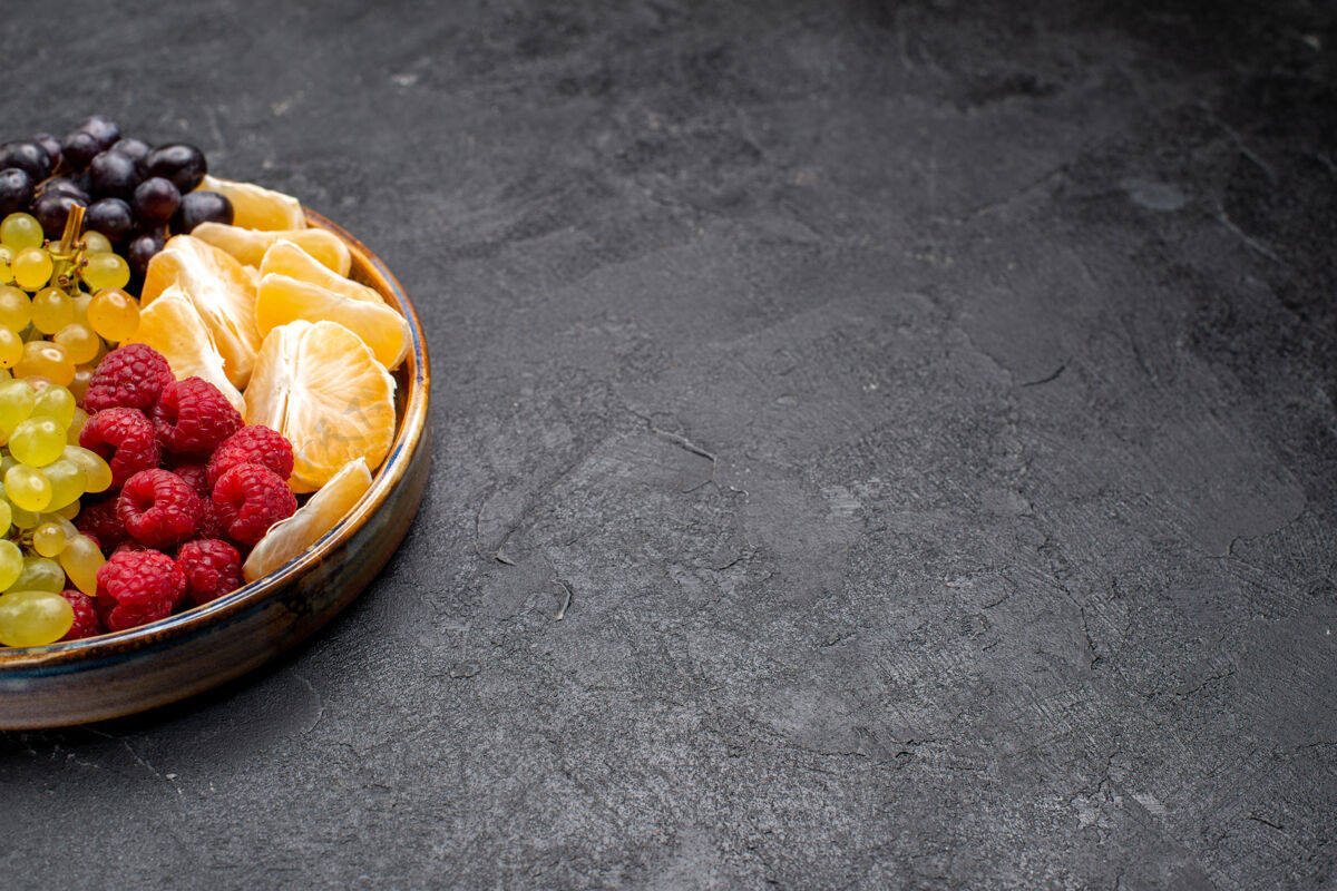 食品前视图水果成分草莓葡萄覆盆子和柑橘托盘内的黑暗空间小吃草莓托盘
