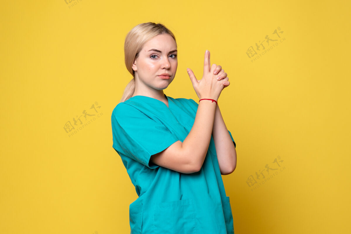 人前视图穿着医疗衬衫的女医生摆姿势 大流行护士医疗covid-19情感流行黄色姿势