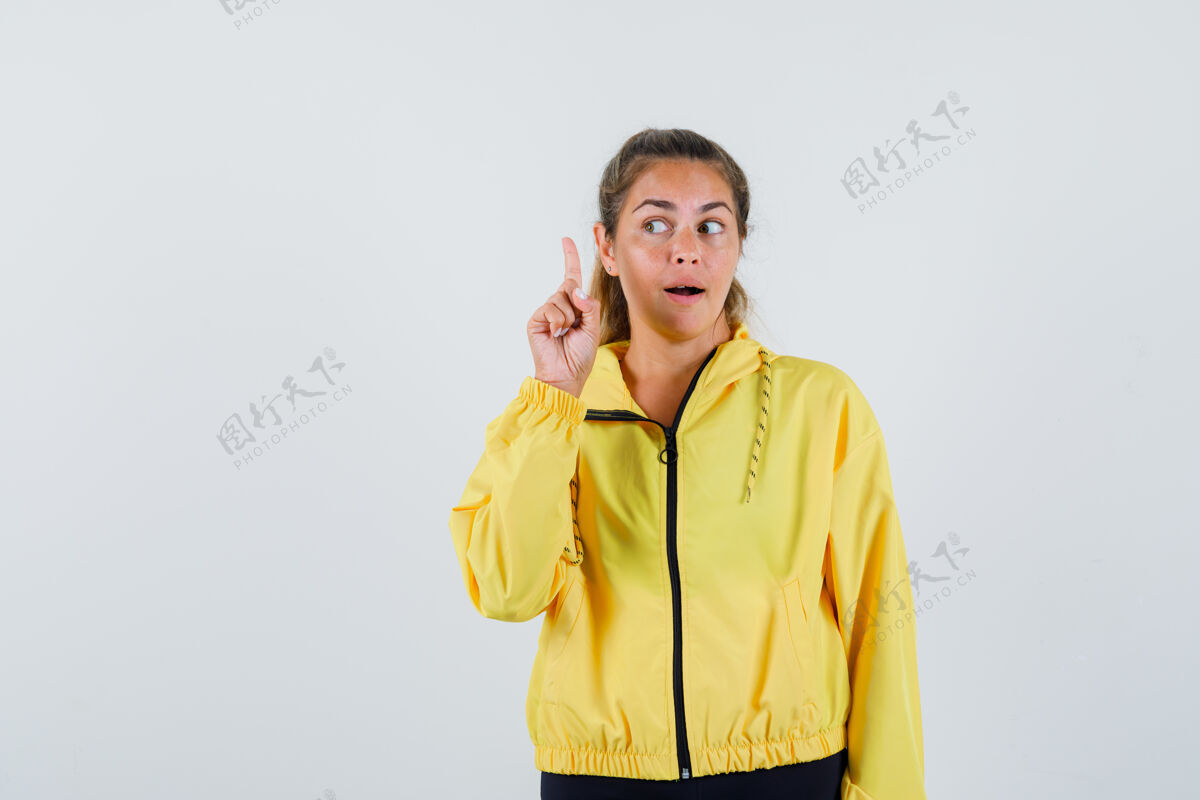 指向一个穿着黄色雨衣的年轻女子一边指着一边仔细地看着爱光一旁