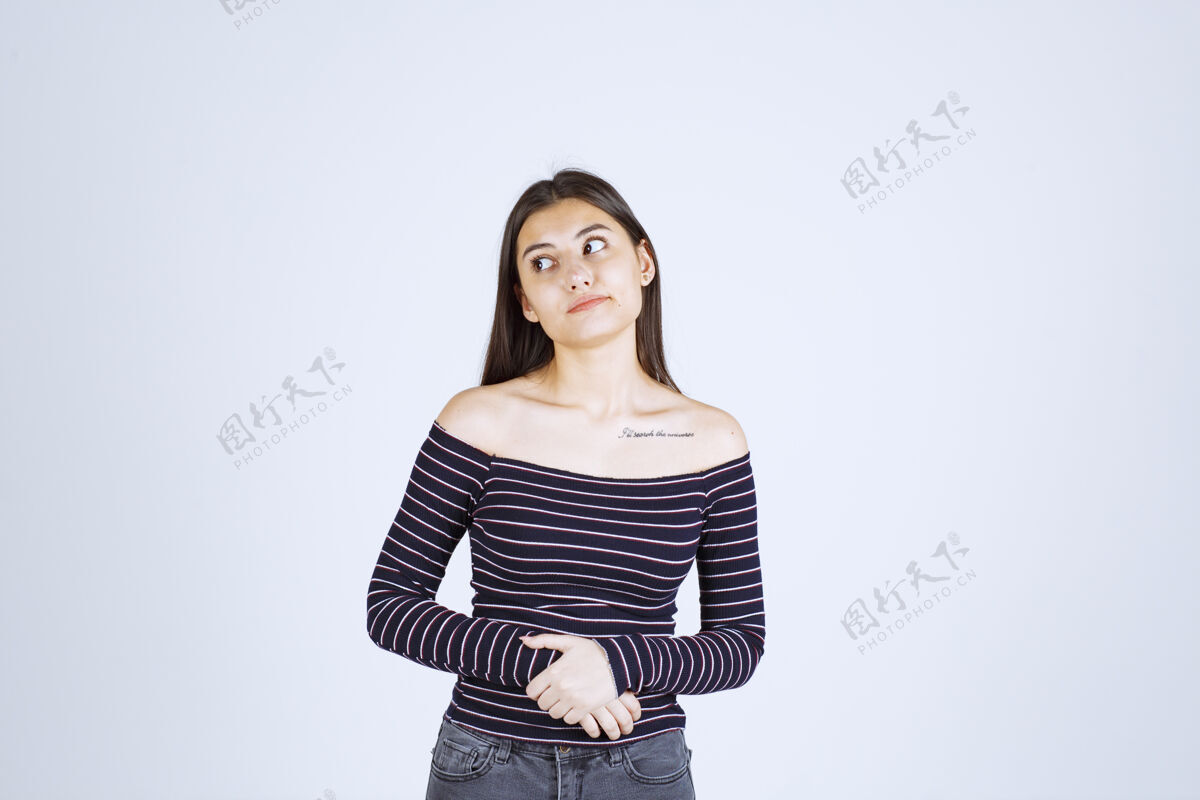 迷路穿条纹衬衫的女孩看起来既困惑又激动随意成人人体模特
