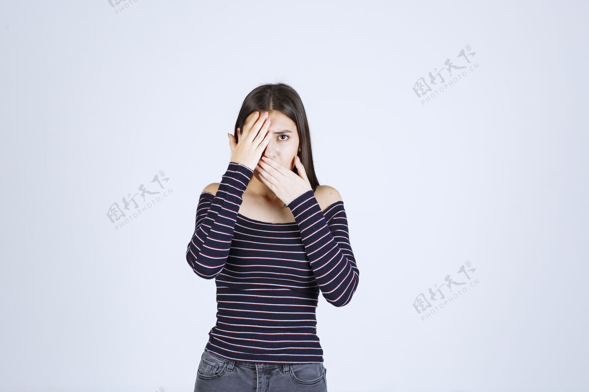 人体模特穿条纹衬衫的女孩透过手指看成人服装员工