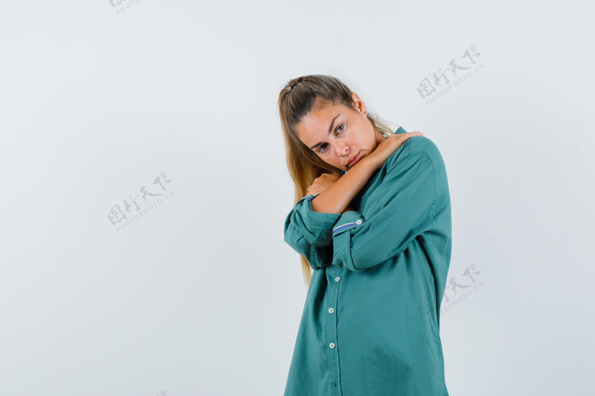 手穿蓝衬衫的年轻女子双手交叉放在肩膀上 看上去很累肖像美女人