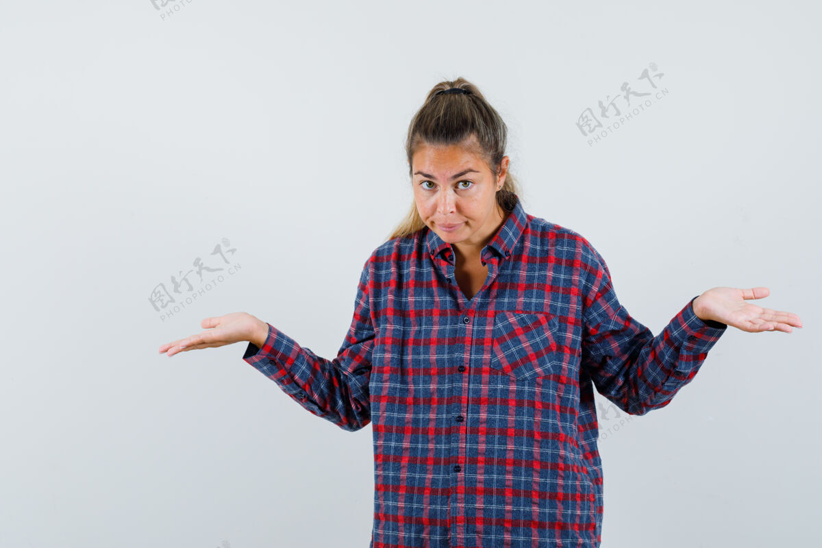问题一个穿着格子衬衫的年轻女人 以询问的方式伸出手 看上去很困惑黑发人干净