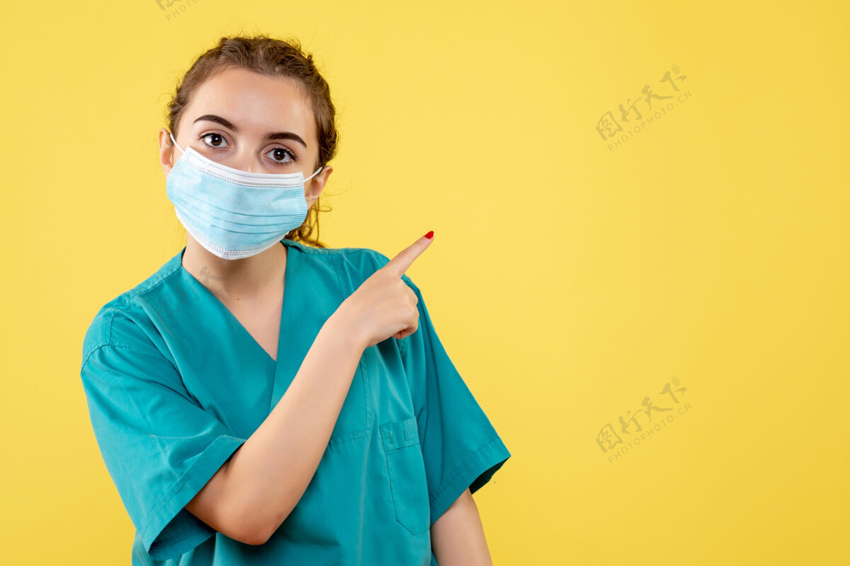 颜色正面图女医生穿着医用衬衫 戴着无菌口罩 颜色均匀的covid-19病毒面具绝育女医生