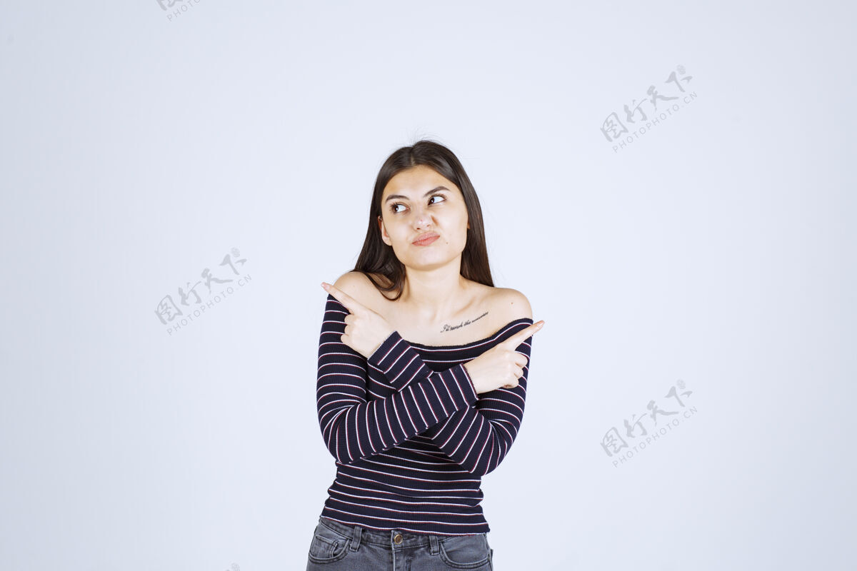 女性穿条纹衬衫的女孩用手指着两边人类成人年轻人