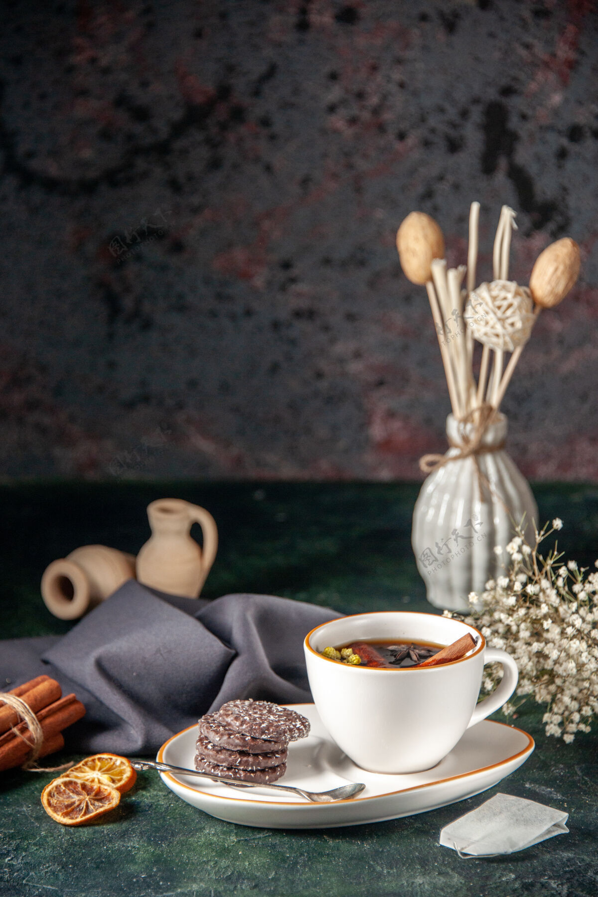 饼干前视图一杯茶加巧克力饼干放在盘子里 托盘在黑暗的表面上仪式玻璃早餐糖蛋糕甜点颜色甜美咖啡仪式杯子
