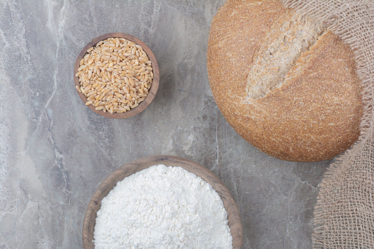 美味一条白面包 在大理石表面涂上燕麦和面粉脆面粉谷物