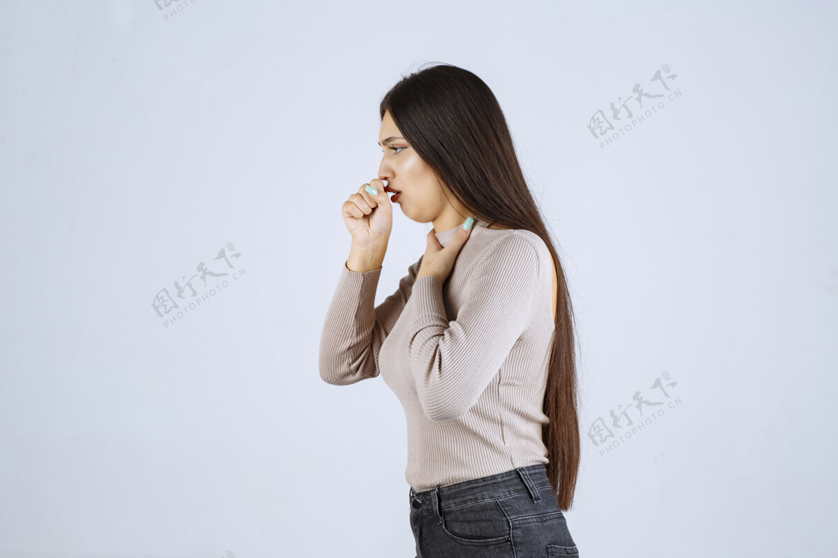 年轻一个穿灰色衬衫的女孩在打嗝 喉咙痛女人年轻人发烧
