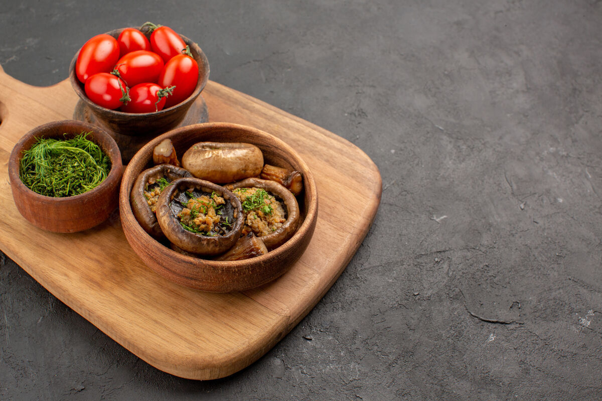 午餐前视图美味的煮熟的蘑菇和西红柿在黑暗的桌子上成熟的野生食物餐厅晚餐一餐