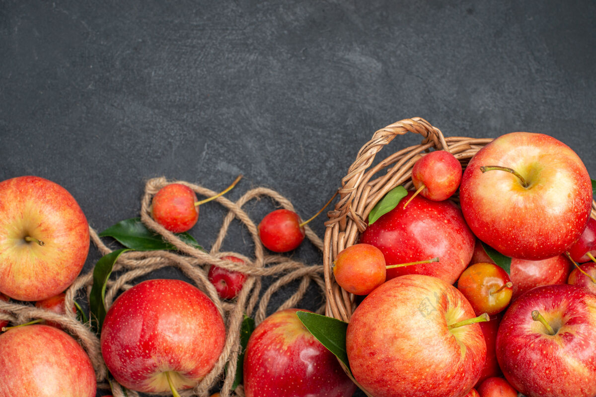 新鲜顶部特写镜头苹果绳开胃的苹果樱桃篮子在黑暗的桌子上农产品饮食樱桃