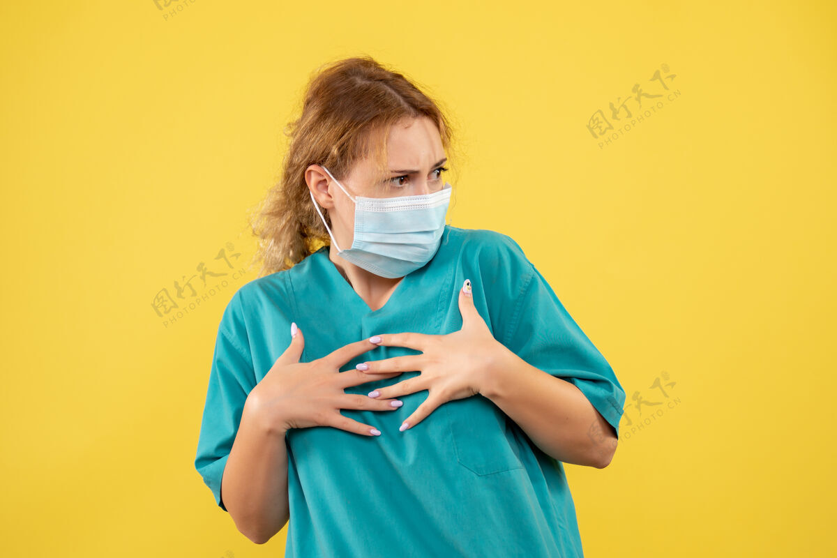 护士黄墙上年轻女医生穿着医疗服 戴着口罩的正面图医疗正面成人