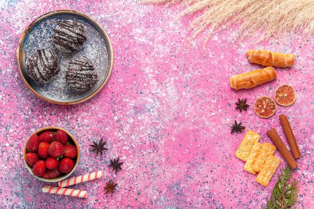肉桂顶视图美味的巧克力蛋糕与百吉饼粉红色蛋糕盘子草莓