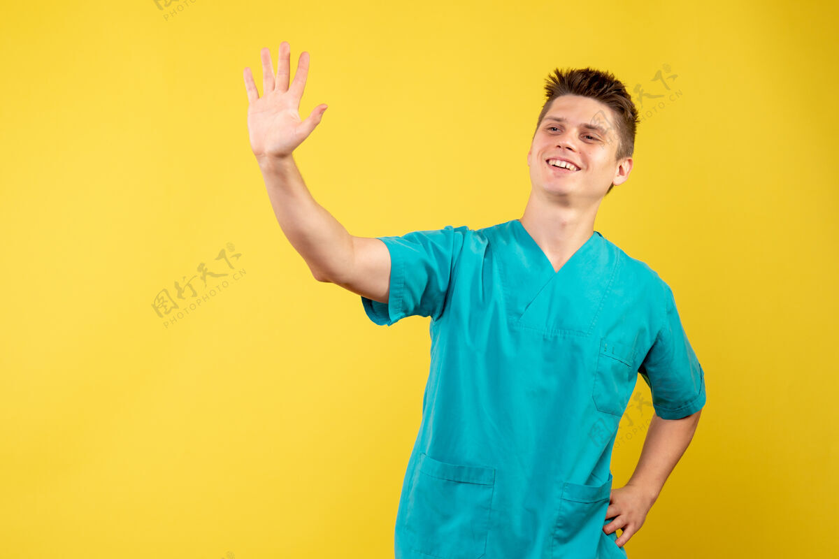 快乐黄色墙壁上穿着医疗服的男医生的正面图西装疾病男性医生