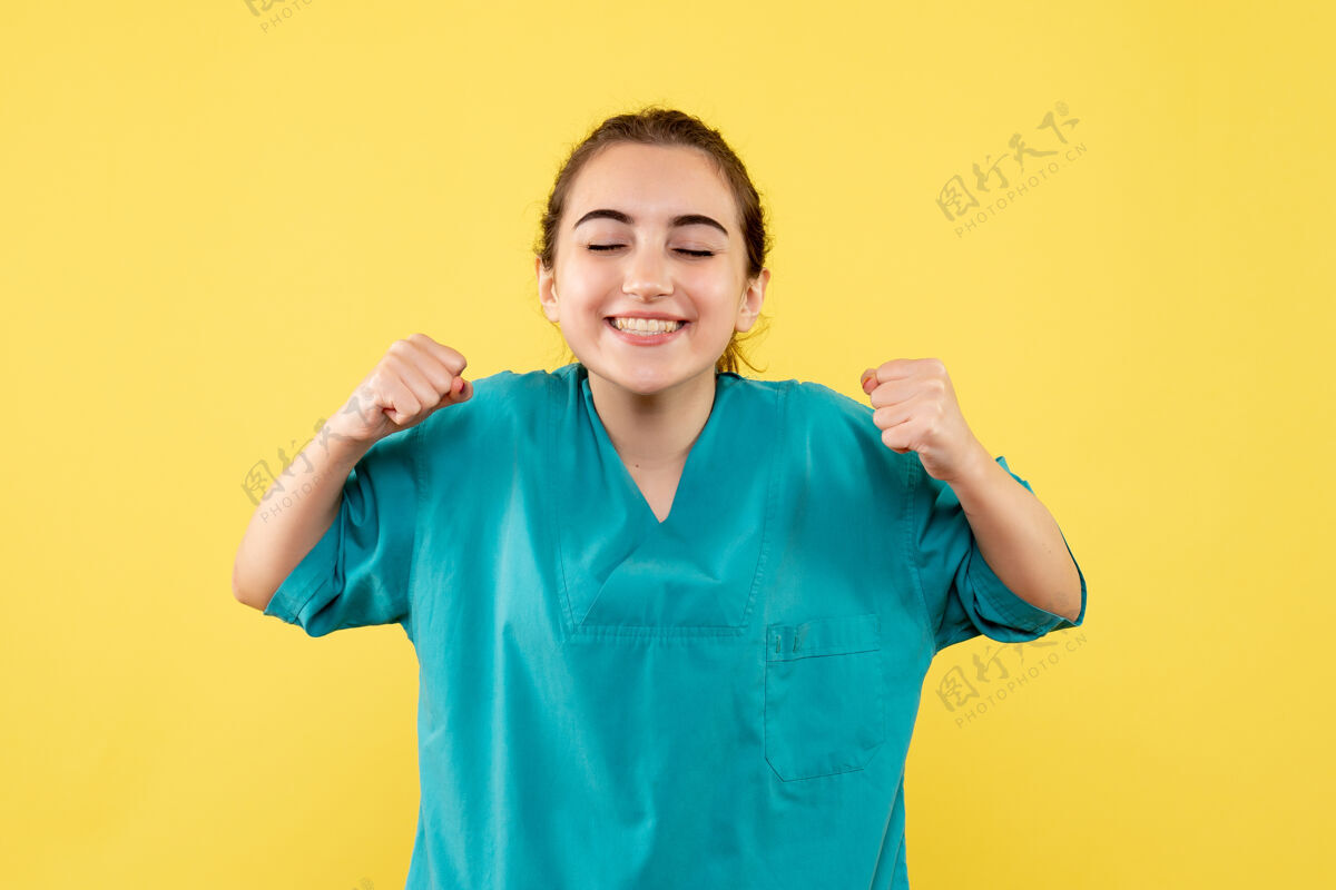 病毒身着医疗服的女医生在黄色墙壁上欢呼雀跃女医生医院高兴