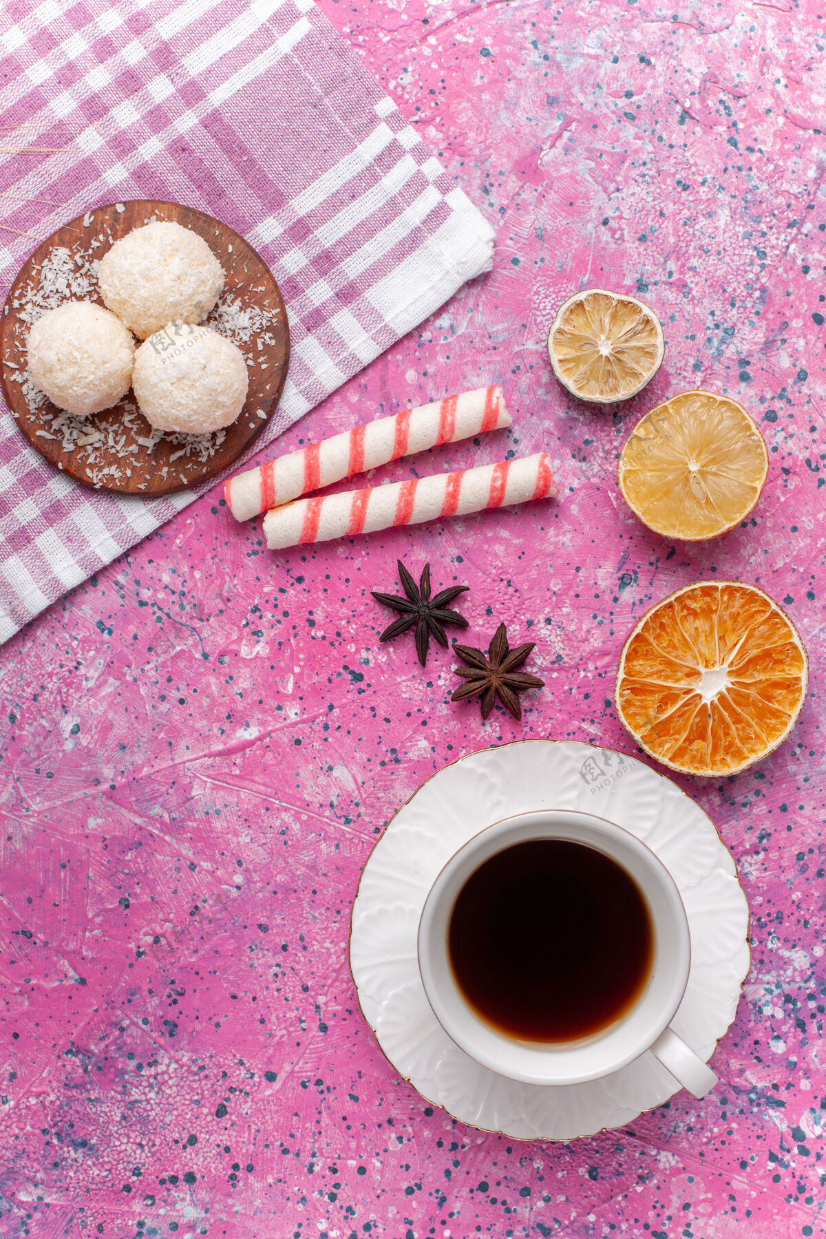 茶顶视图一杯柠檬茶和面团上的亮粉色糖果餐巾杯子