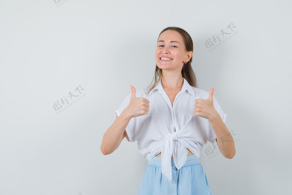 模特穿着衬衫和裙子的年轻女士竖起大拇指 看上去很高兴头发快乐头