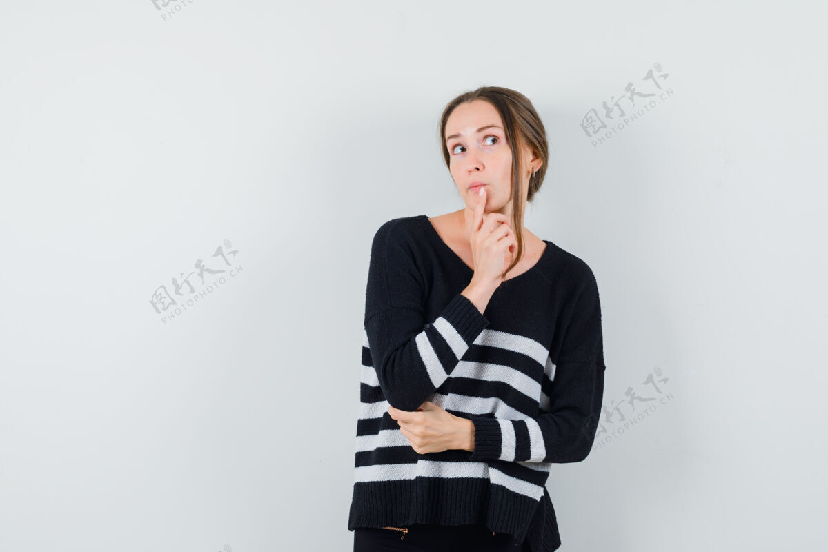 衬衫穿着休闲衬衫的年轻女士 手指放在下巴上 神情沉思黑发人干净