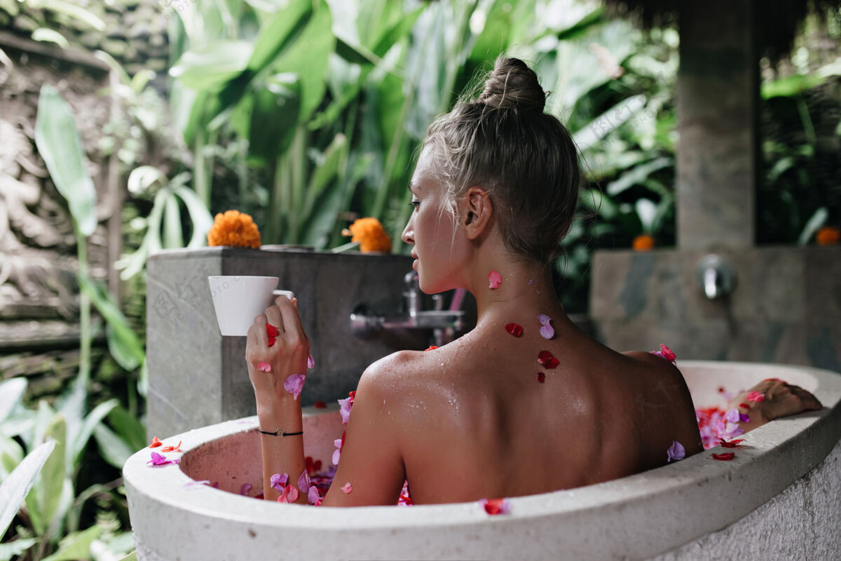 卫生可爱的金发女人早上喝咖啡 躺在浴缸里休闲金发成人