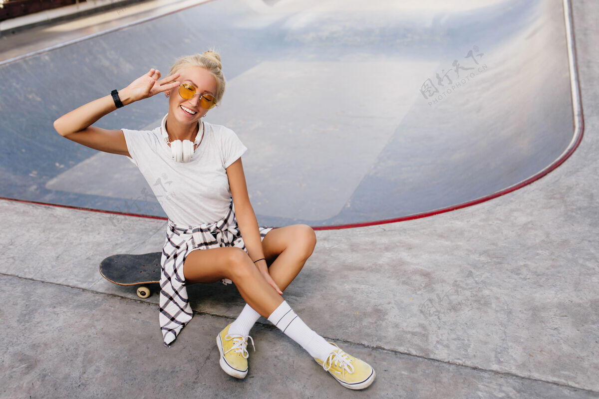 欢乐有趣的溜冰女 时尚的发型 表达积极的情绪溜冰公园里快乐的女模特的户外肖像滑板活动长板