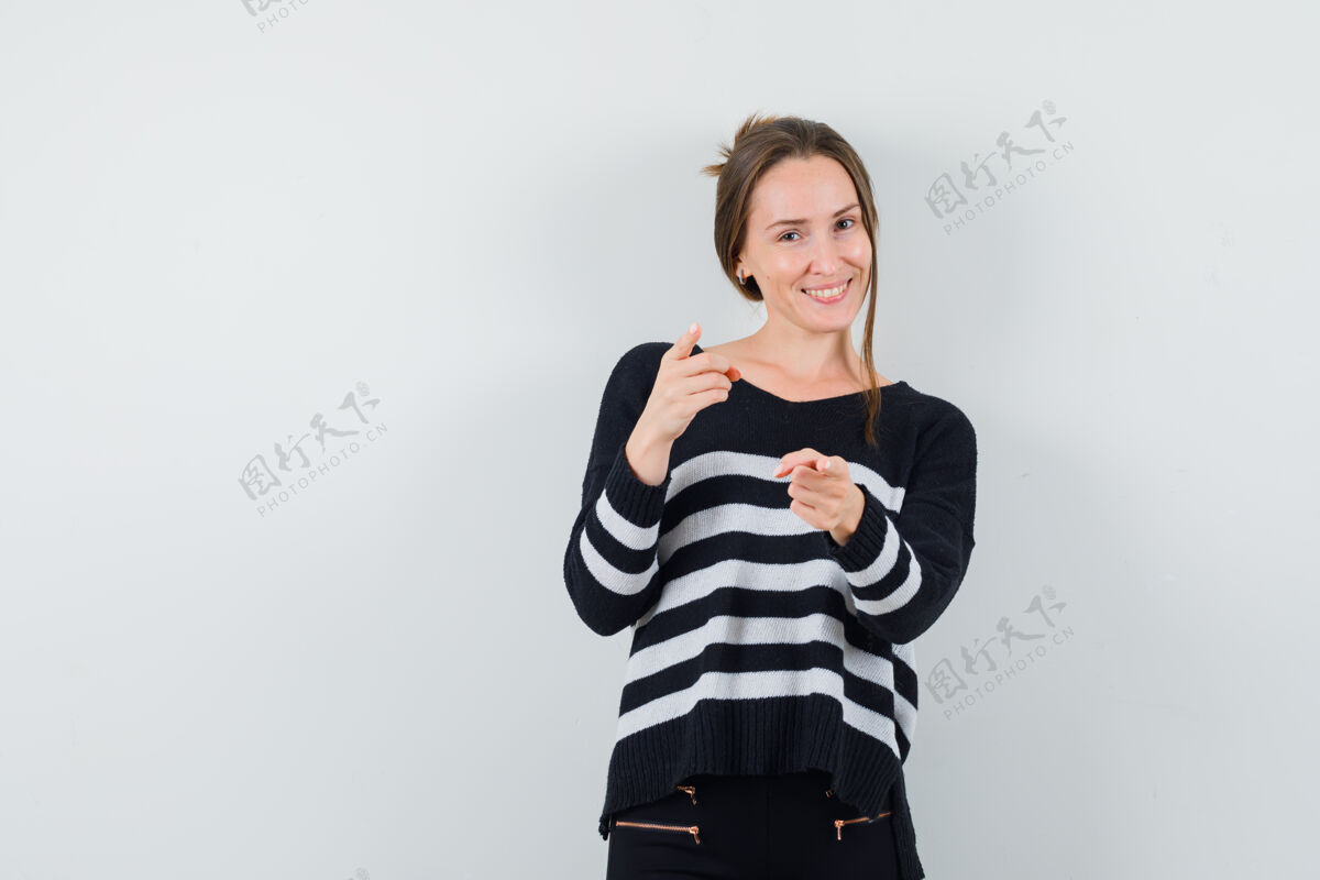 年轻穿着休闲衬衫的年轻女士指着前面 看上去很高兴干净指尖美丽