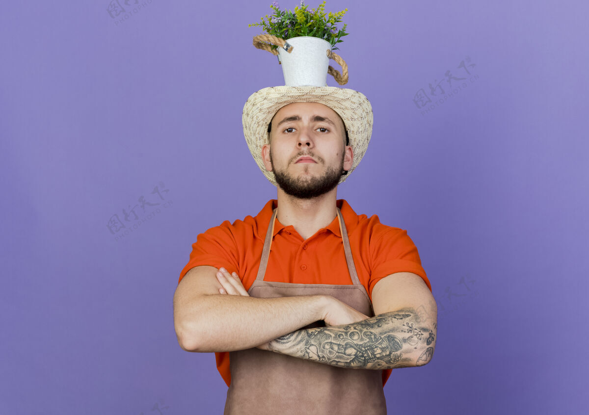 手臂自信的男园丁戴着园艺帽 头戴花盆 双臂交叉头园艺花园