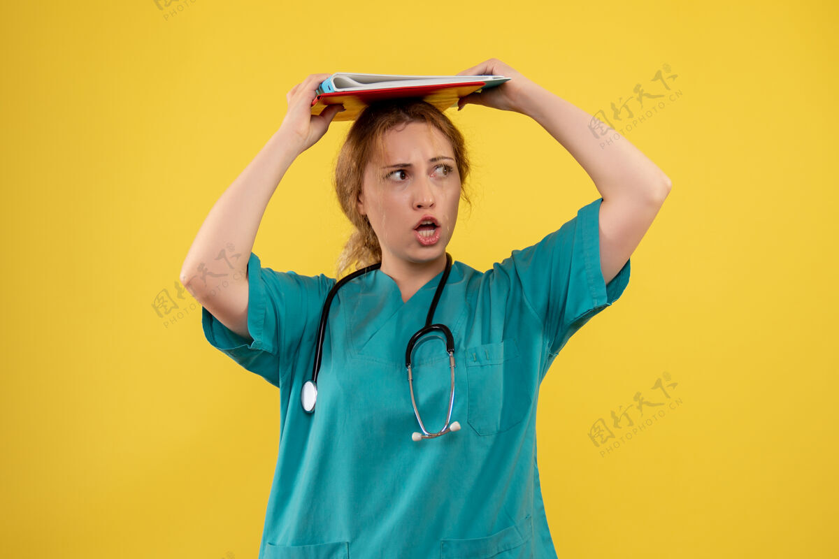 前面黄色墙壁上穿着医疗服的女医生的正面图医学女医生人