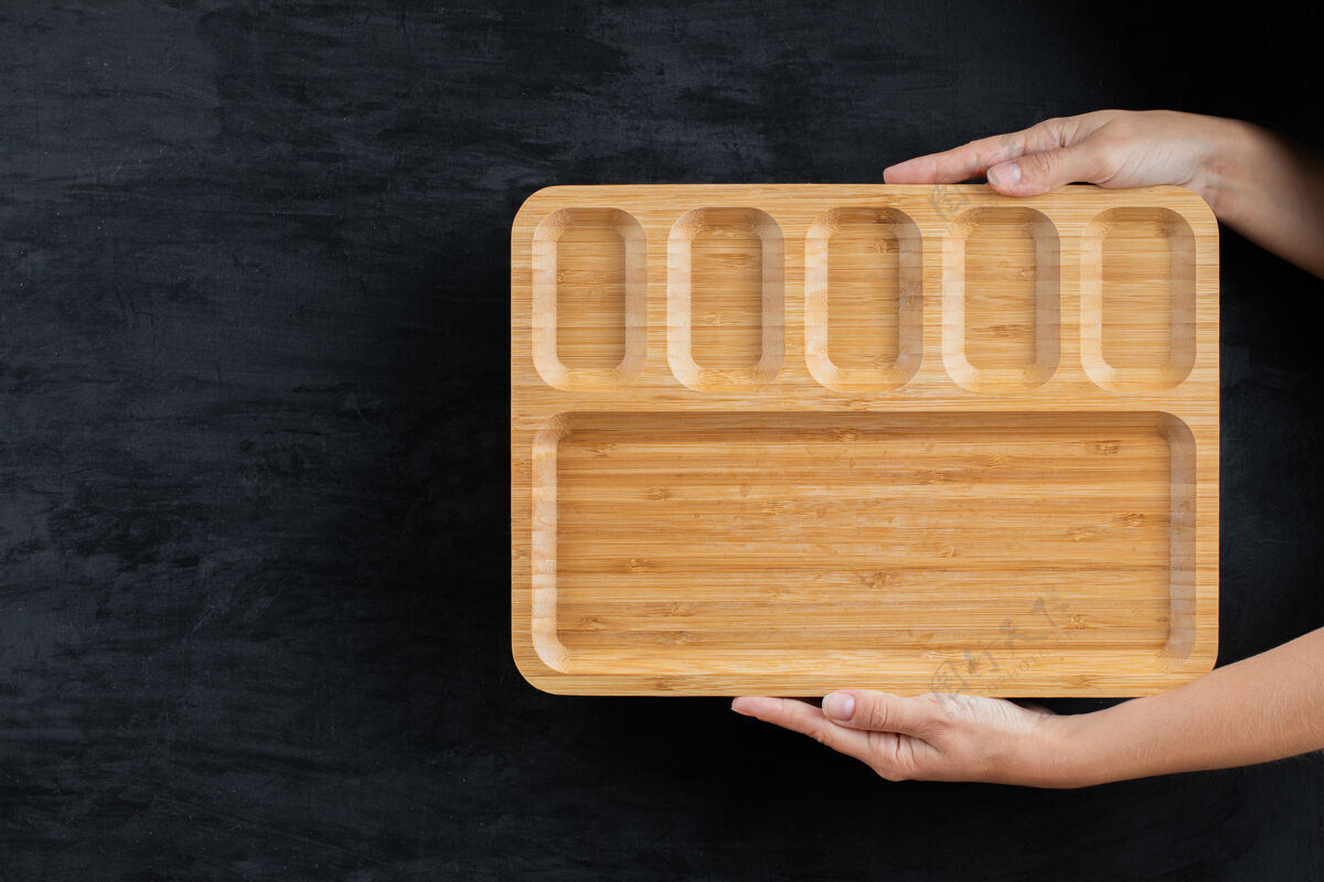 晚餐用手拿着一个方形的木盘餐具传统美味