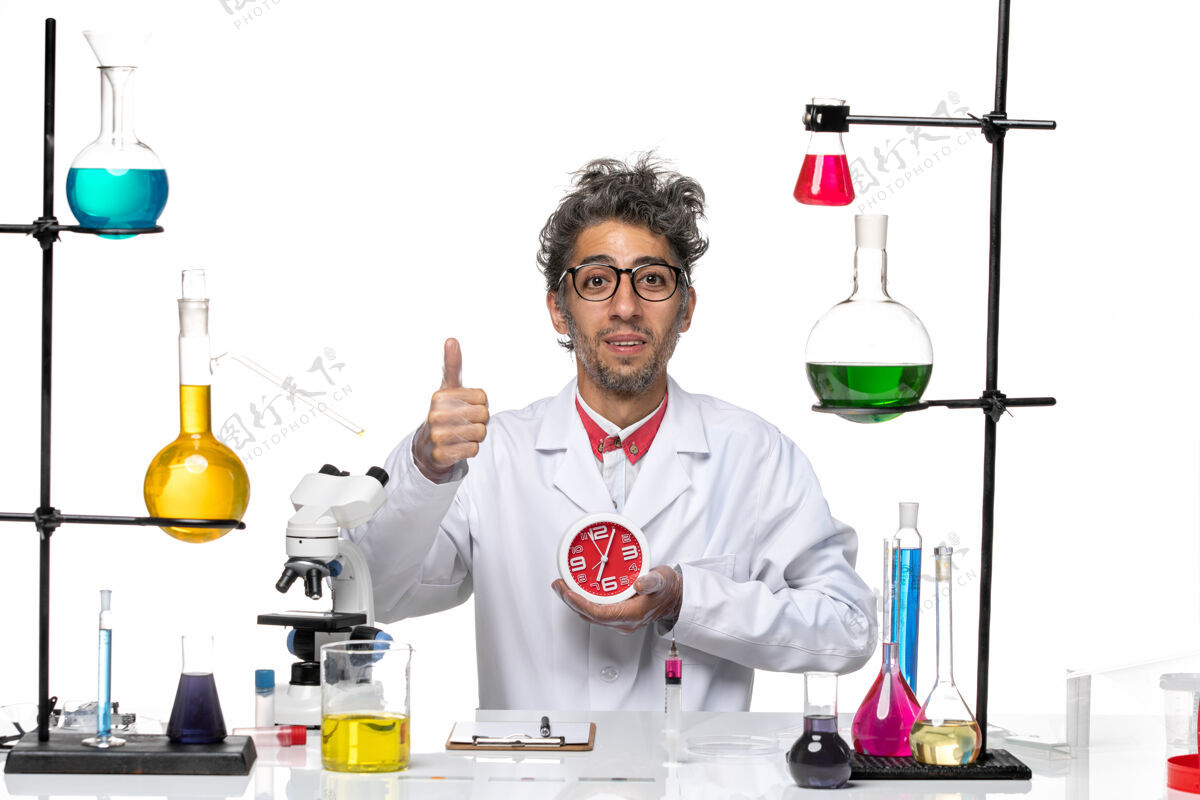 实验室正面图身穿医疗服的男科学家手持时钟 在白色背景上微笑着化学冠状病毒-实验室病毒健康病毒轮时钟