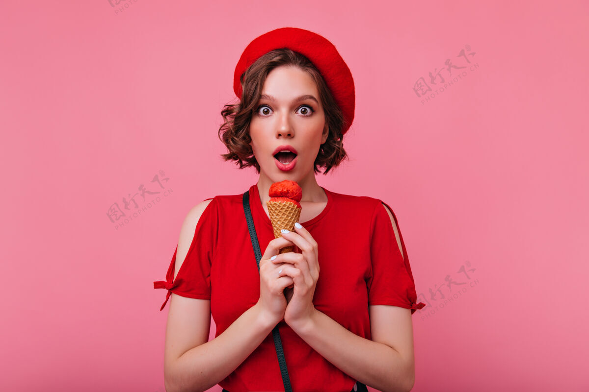 表情时尚女孩吃冰淇淋 表达惊奇室内照片可爱的法国女士在时尚的红色贝雷帽可爱女人女性