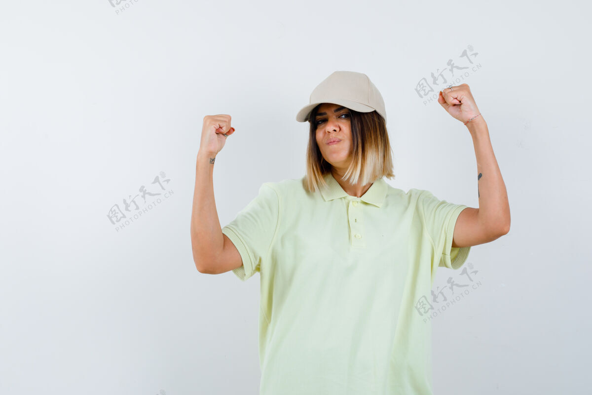 女孩年轻女性穿着t恤衫 戴着帽子 展现着赢家的姿态 看上去很幸运 正面视图头部成人赢家