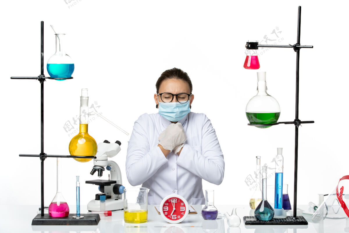 实验室前视图：穿着医疗服的女化学家 戴着面罩 坐在白色背景上 溶液发抖 化学实验室的病毒冠状病毒-飞溅解决方案飞溅前面