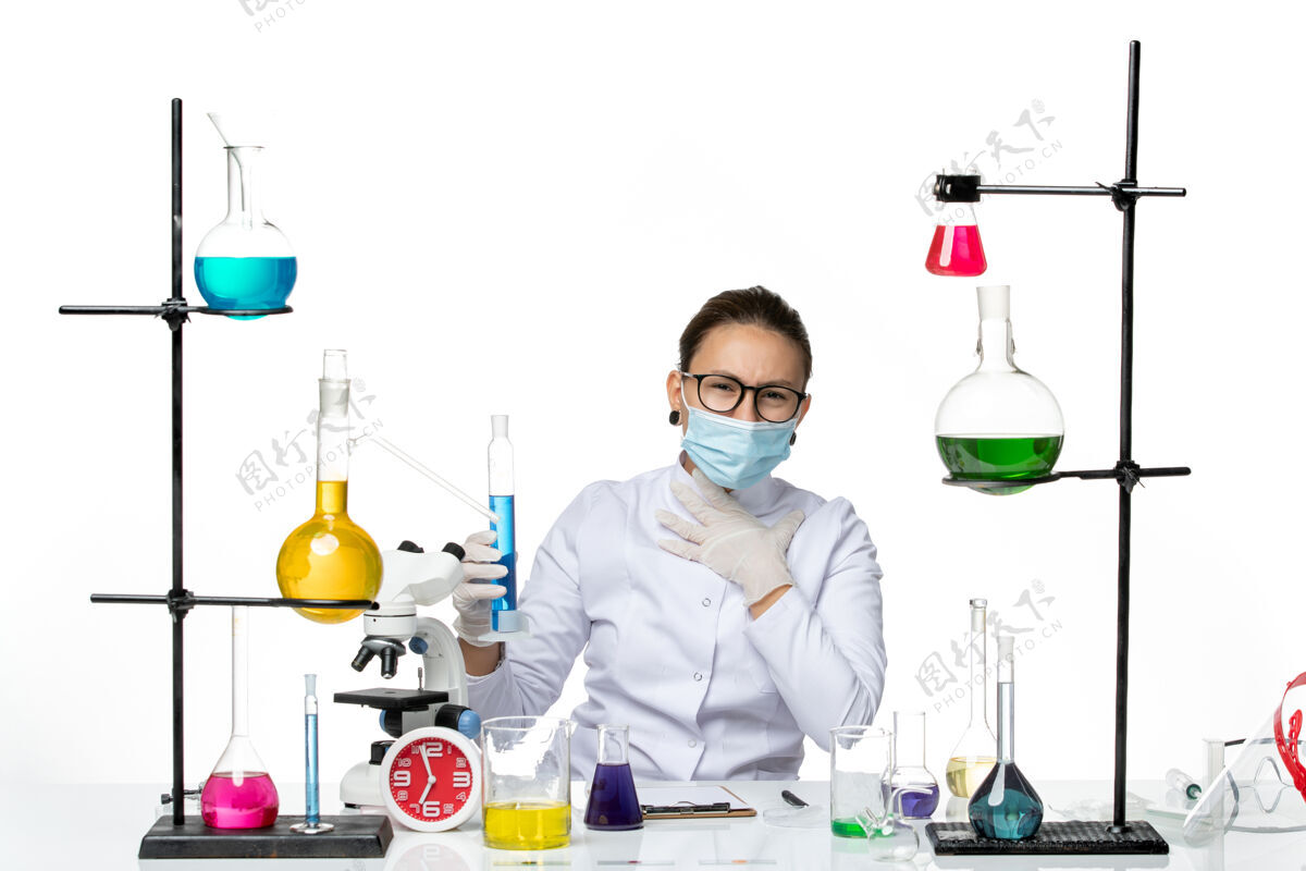 实验室前视图穿着医疗服的女化学家戴着面罩拿着装有蓝色溶液的烧瓶在白色地板上溅出病毒化学实验室病毒前面瓶子地板