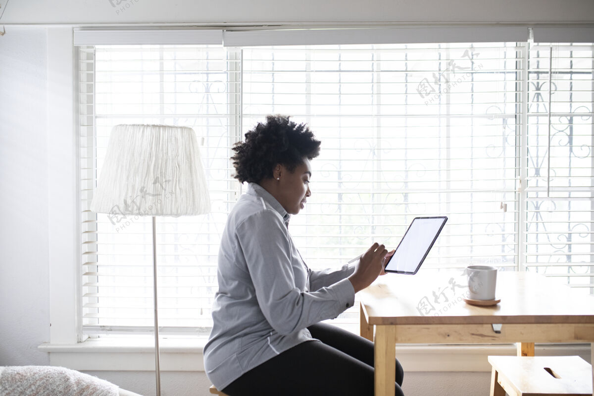 女人在新常态下 一个在数字平板电脑上工作的女人屏幕数字设备自由职业者