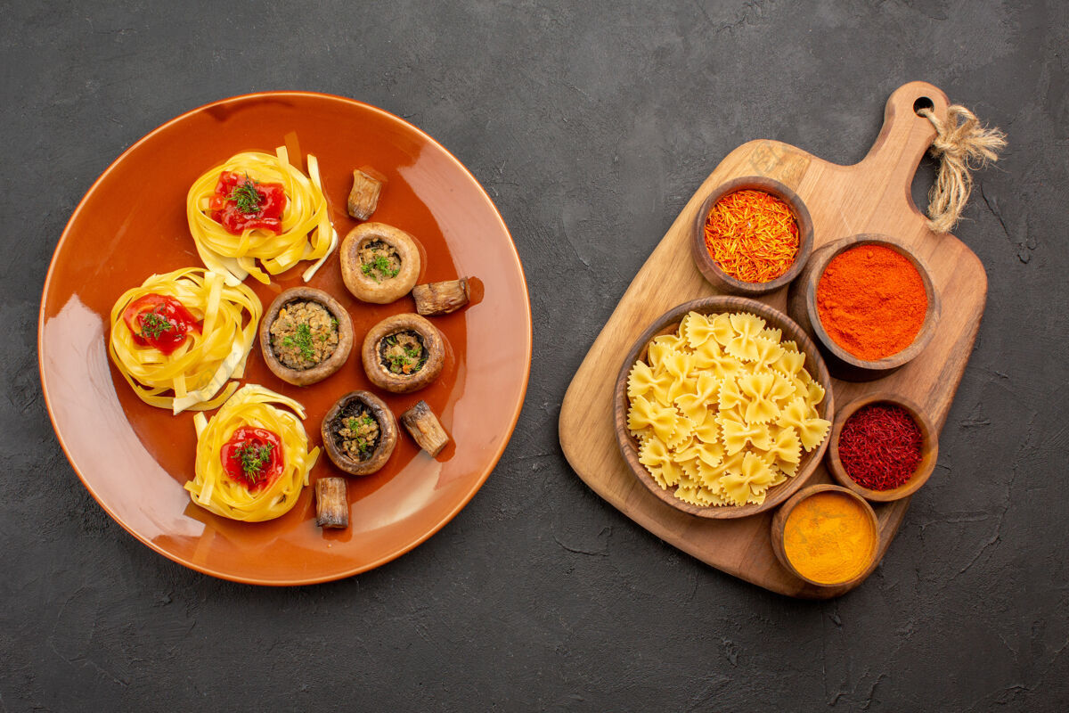 蔬菜在灰色背景上 俯瞰美味的熟蘑菇和调味品胡椒盘子晚餐