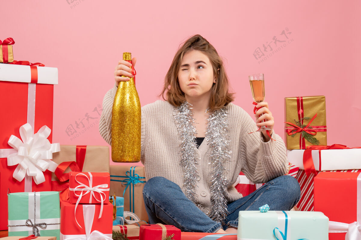 年轻女性正面图年轻女性围坐在圣诞节礼物庆祝香槟情感微笑节日